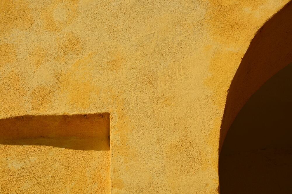 Yellow architectural wall photographed by Sara Luccarelli